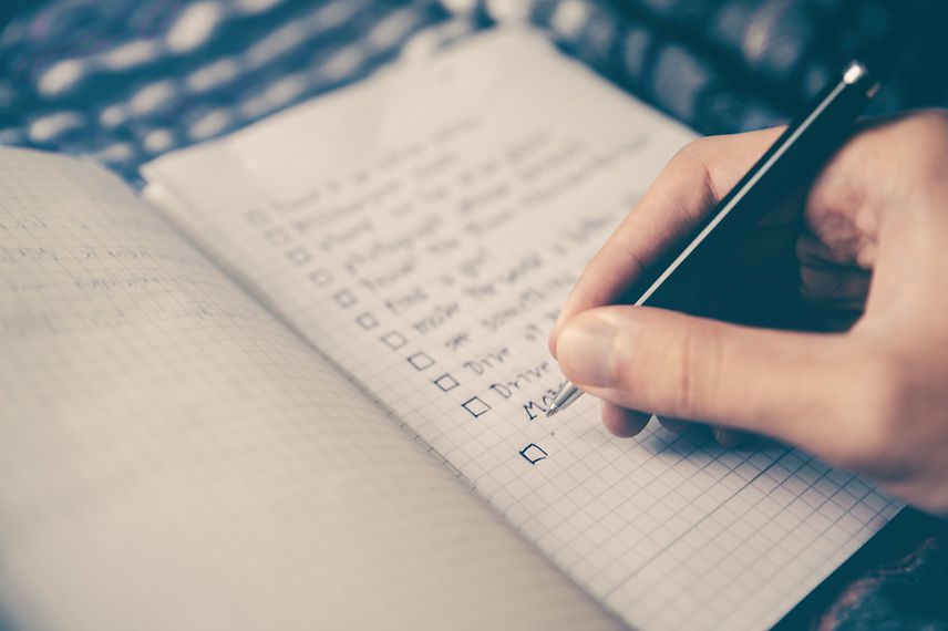 Hand with pen writing a to-do list - education business services