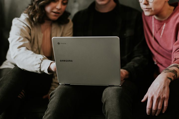 Three people working as a team on one laptop - Katie Stone, Education Business Services